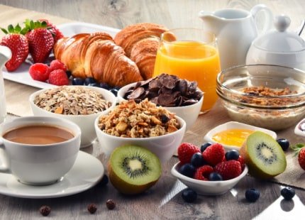 Breakfast served with coffee, orange juice, croissants, cereals and fruits